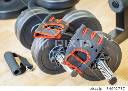Dumbbells with fitness equipment on floor Dumbbells with fitness equipment on floor 34602737