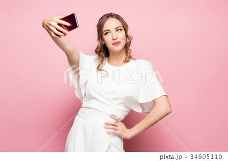 Portrait of a young attractive woman making selfie 34605110