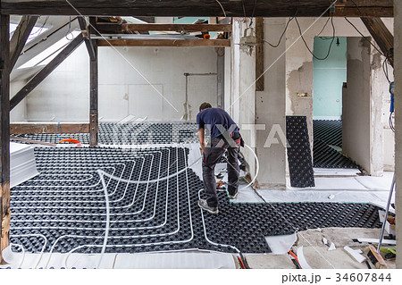 Pipe fitter mounting underfloor heating. 34607844