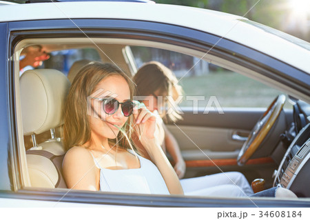 The young women in the car smiling 34608184