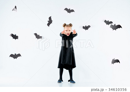 Little girl witch in black dress over magical 34610356