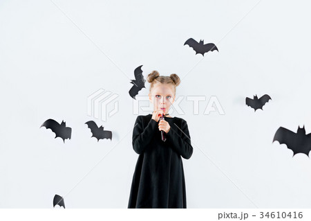 Little girl witch in black dress over magical 34610416