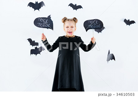 Little girl witch in black dress over magical 34610503