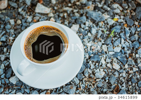 White cup of hot coffee on gray stone ground White cup of hot coffee on gray stone ground 34615899