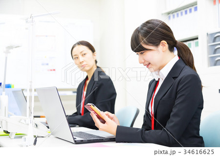 スマホを使う女性社員　OL　ビジネスマン　サラリーマン　パソコン　オフィスイメージ　ビジネスイメージ 34616625