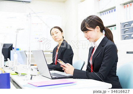 スマホを使う女性社員　OL　ビジネスマン　サラリーマン　パソコン　オフィスイメージ　ビジネスイメージ 34616627