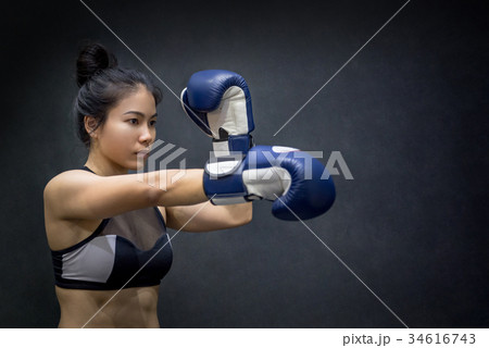 young Asian woman posing with boxing gloves young Asian woman posing with boxing gloves 34616743
