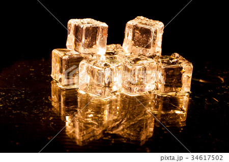 Gold ice cubes on black background. 34617502