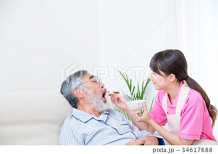 介護職　寝たきり高齢者に食べさせる　高齢者介護　介助シーン　食事介助　介護士 34617688