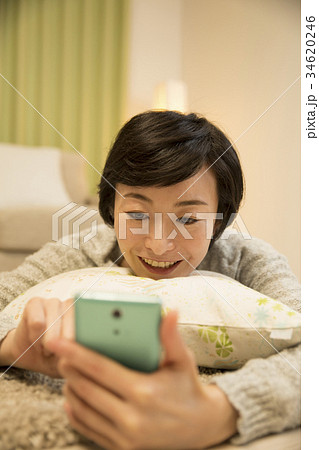 寝そべりながらスマホを操作するアラフォー女子 34620246