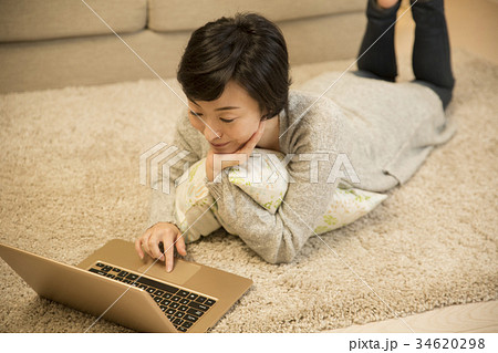 寝そべりながらPCを眺めるアラフォー女子 寝そべりながらPCを眺めるアラフォー女子 34620298
