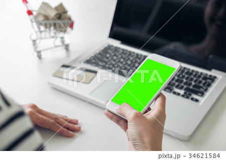 Happy Woman using smart phone and credit card register payments Happy Woman using smart phone and credit card register payments 34621584