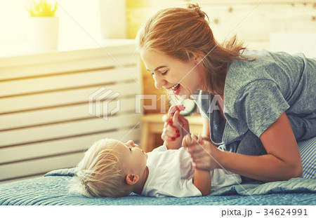 happy family mother and baby son laughing in bed happy family mother and baby son laughing in bed 34624991