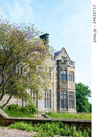 イギリス郊外の歴史的建物と手入れされた庭園の写真素材