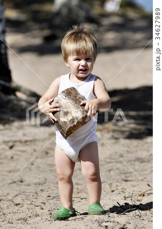 Happy little child plays with chopped billet Happy little child plays with chopped billet 34627989