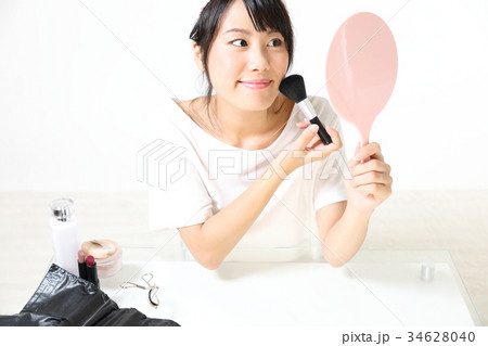 若い女性　メイクアップ　チークブラシ 34628040