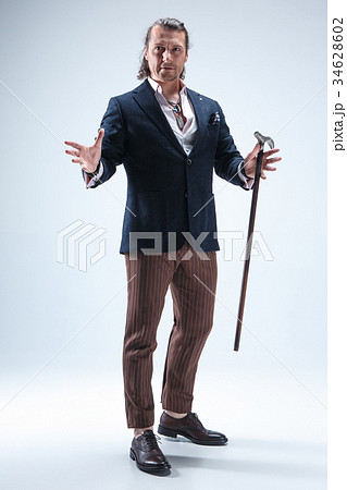 The mature barded man in a suit holding cane. The mature barded man in a suit holding cane. 34628602