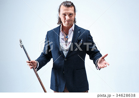 The mature barded man in a suit holding cane. The mature barded man in a suit holding cane. 34628638