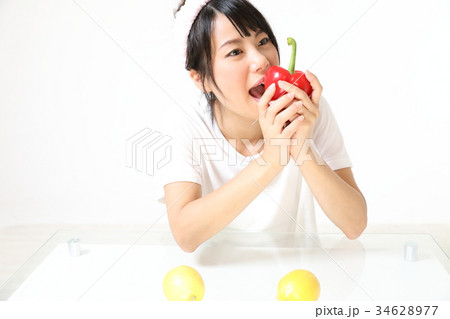 若い女性　赤いパプリカを食べる 34628977