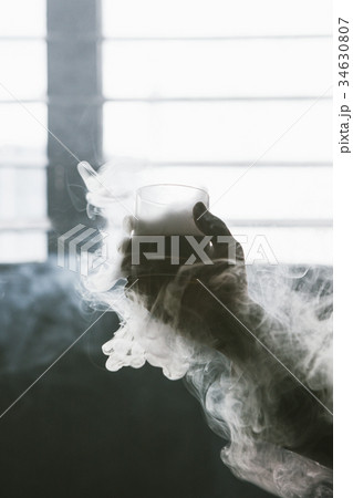 Creative alcoholic cold drink with white smoke 34630807