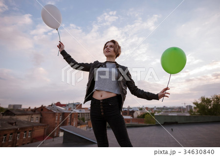 Enigmatic young woman with two toy balloons 34630840