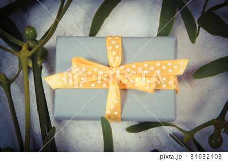 Wrapped gift for Christmas and mistletoe Wrapped gift for Christmas and mistletoe 34632403
