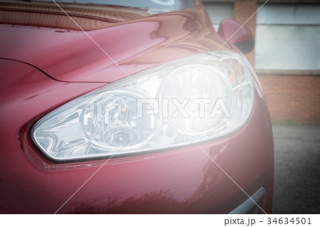 Close-up headlight of red modern car Close-up headlight of red modern car 34634501