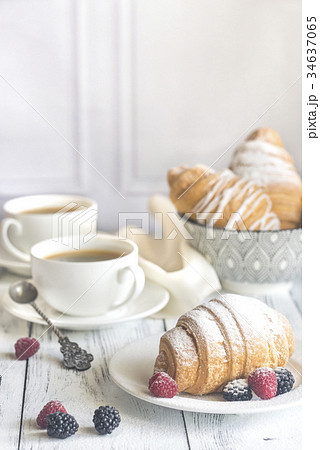 Croissants with fresh berries and cups of coffee 34637065