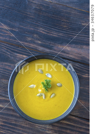 Bowl of pumpkin cream soup on the wooden table 34637079
