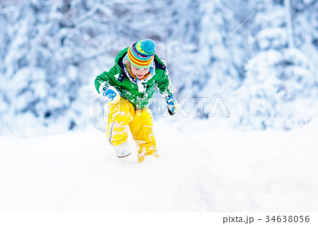 Child playing with snow in winter. Kids outdoors. Child playing with snow in winter. Kids outdoors. 34638056