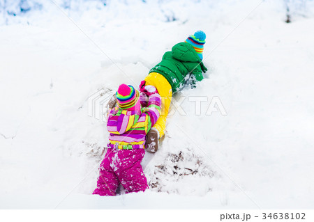 Kids playing in snow. Children in winter snowfall. 34638102