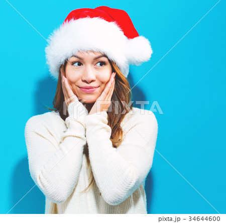 Happy young woman with Santa hat Happy young woman with Santa hat 34644600