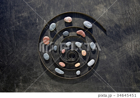 metal spring spiral and sea stone time concept 34645451