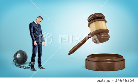 A small sad businessman leashed to an iron ball 34646254