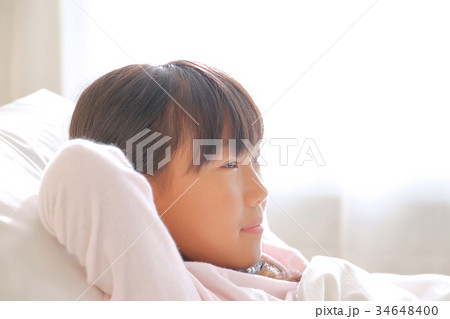 ベッドで寝る女の子の写真素材