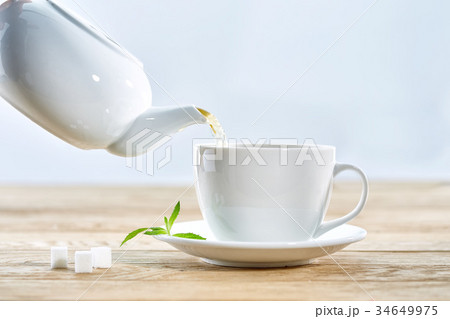 cup with green tea and teapot on white wooden cup with green tea and teapot on white wooden 34649975