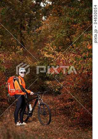 back view of a man with a bicycle and red backpack 34650054