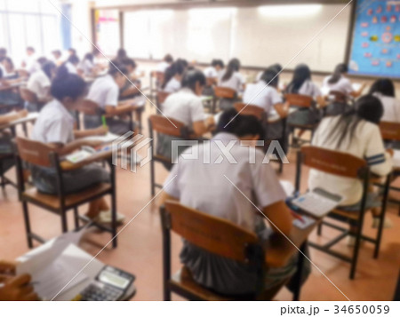 Blur students doing exam in classroom 34650059