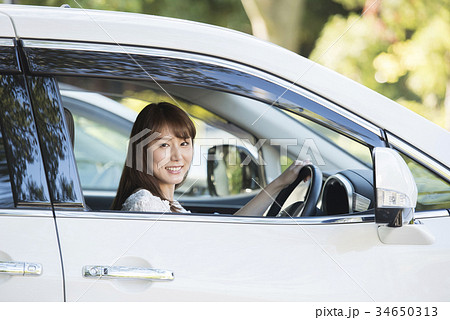 車の運転席の女性 カメラ目線の写真素材