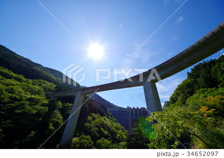 見上げる青空とループ橋 奥秩父 雷電廿六木橋 F 太陽の光芒とダムの写真素材