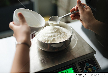 Bakery chef weighing flour on the digital scale 34654233