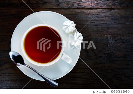 A cup of tea on a rustic wooden board, top view 34655640