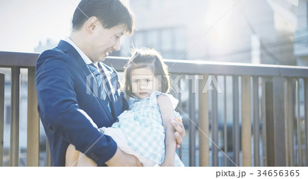 屋外で娘を抱っこする親 屋外で娘を抱っこする親 34656365
