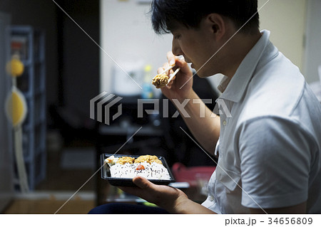 部屋で弁当を食べる男性 34656809