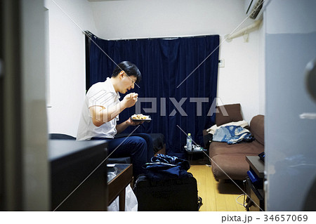 部屋で弁当を食べる男性 34657069
