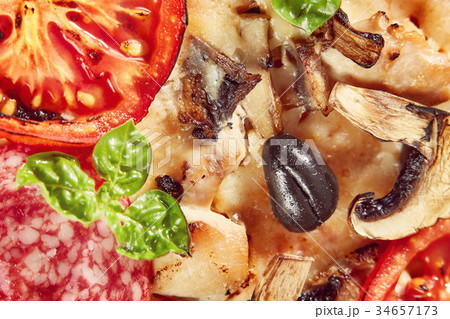 Closeup of pizza with salami, tomatoes and olives 34657173