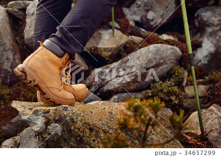 hiking boots on the rock in the mountains. hiking boots on the rock in the mountains. 34657299