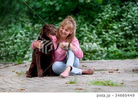 smiling girl relaxing with dog.Labrador sitting 34660449