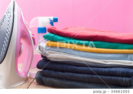 Pile of colorful clothes and irons,spray bottles  34661093