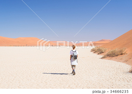 Tourist walking Sossusvlei, Namib desert Tourist walking Sossusvlei, Namib desert 34666235